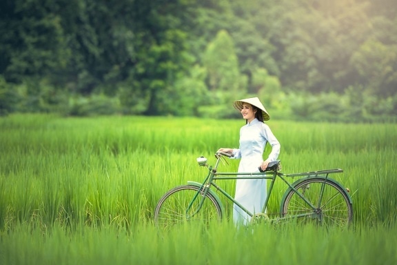 Aziatisch meisje, fiets, groen gras, gelukkig, landschap, vrije tijd, lifestyle, buitenshuis
