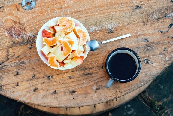 bowl, fruit, salad, coffee cup, spoon, table