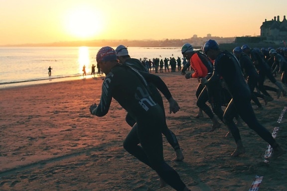 เงา triatlon กีฬา นักกีฬา ฝูงชน อาทิตย์ตก น้ำ ชายหาด คน การแข่งขัน