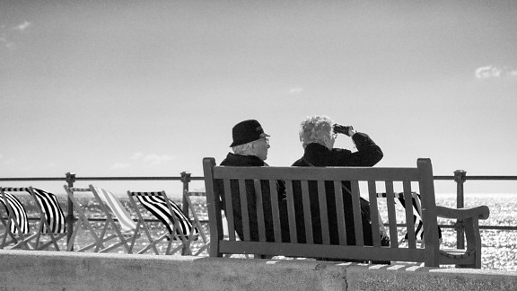 people, beach, fence, monochrome, daylight, bench, sea, ocean, chair, outdoor