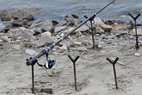 equipment, fishing gear, fishing rod, object, riverbank, rocky river, water, landscape, nature, sand