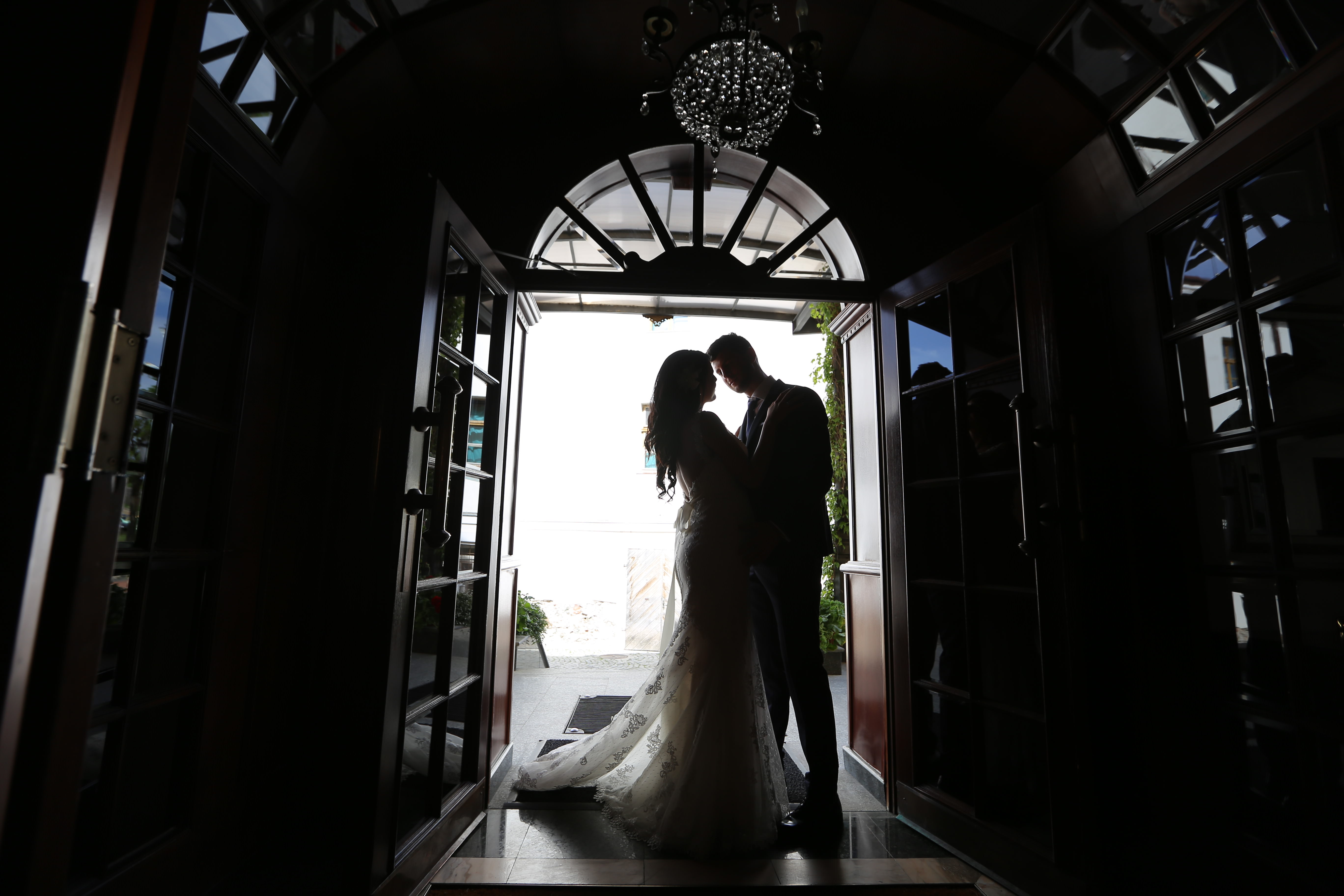 フリー写真画像 花嫁 シャンデリア 入り口 正面玄関 ゲート 新郎 キス シルエット ドレス 結婚式