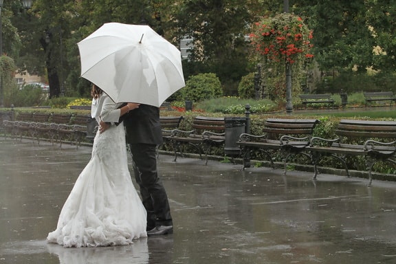 bad weather, hug, kiss, rain, romantic, suit, wedding, wedding dress, bride, umbrella