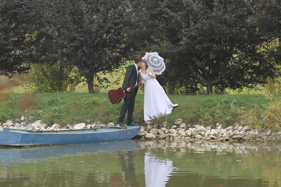 groom, guitarist, kiss, musician, riverbank, umbrella, wedding dress, water, girl, people