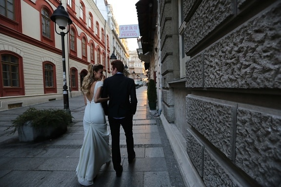 wife, wedding dress, husband, outfit, walking, suit, street, architecture, sidewalk, building