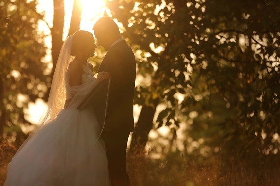 hug, embrace, beautiful photo, sunny, sunrays, bride, groom, sun, candle, wedding