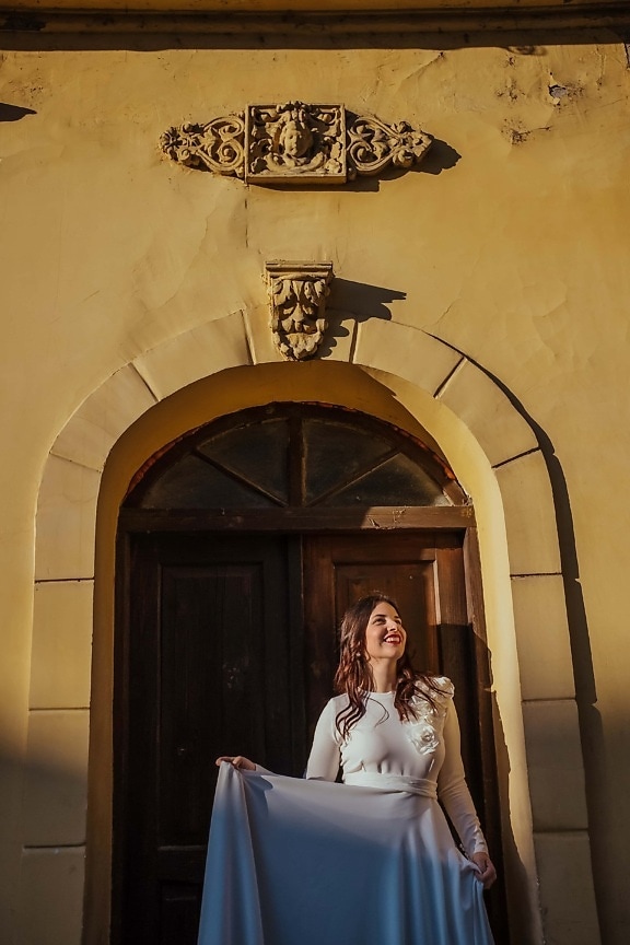 front door, smiling, exhilaration, young woman, dress, sunny, posing, church, building, architecture