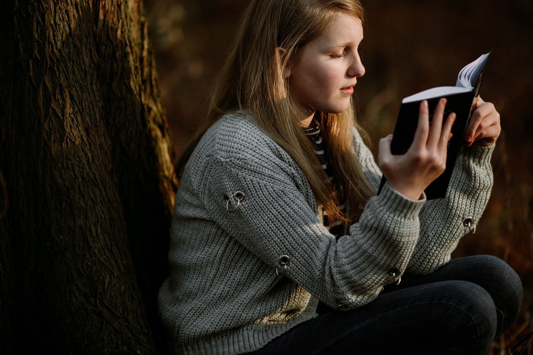 young woman, student, reading, book, tree, outdoor, outfit, sweater, knitwear, cardigan
