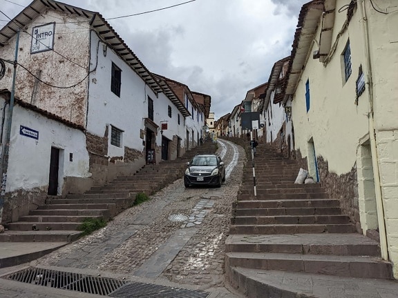 downhill, slope, street, narrow, road, car, architecture, building, wall, town