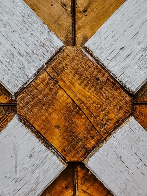 Texture of white hardwood planks with close-up of wooden cube painted in brown at center