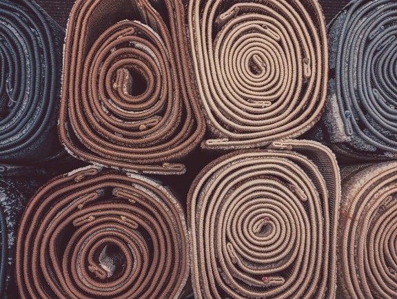 Различни килим стоки в спирална форма близък план текстура