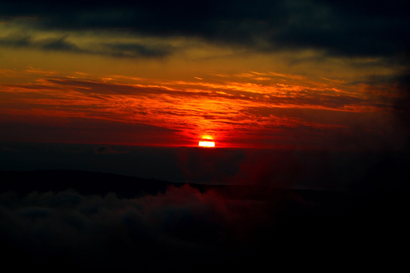 Panoramă de apus de soare roșu închis, cu nori pe cer seara