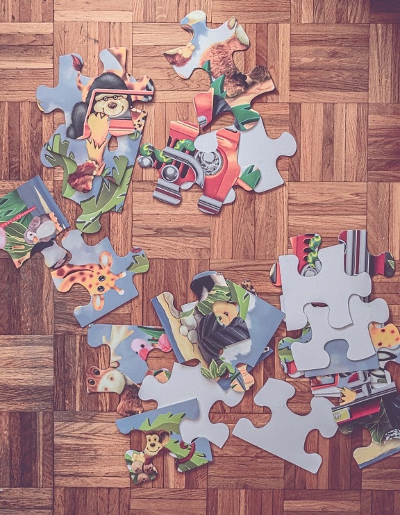 Old jigsaw puzzle game with big parts on old parquet floor