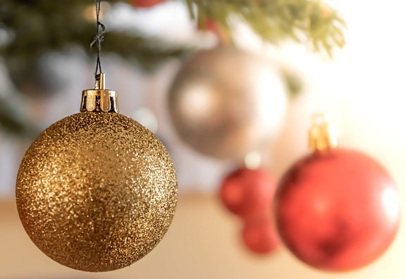 Ukras zlatnog sjaja visi na božićnom drvcu