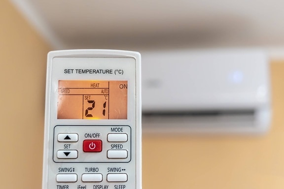 Air conditioner remote control set to heating with room temperature at 21 degree Celsius  (21° C)