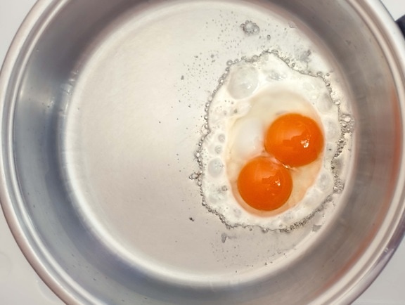 vajce s dvojitým žĺtkom, pečenie čerstvého bio vajíčka na panvici
