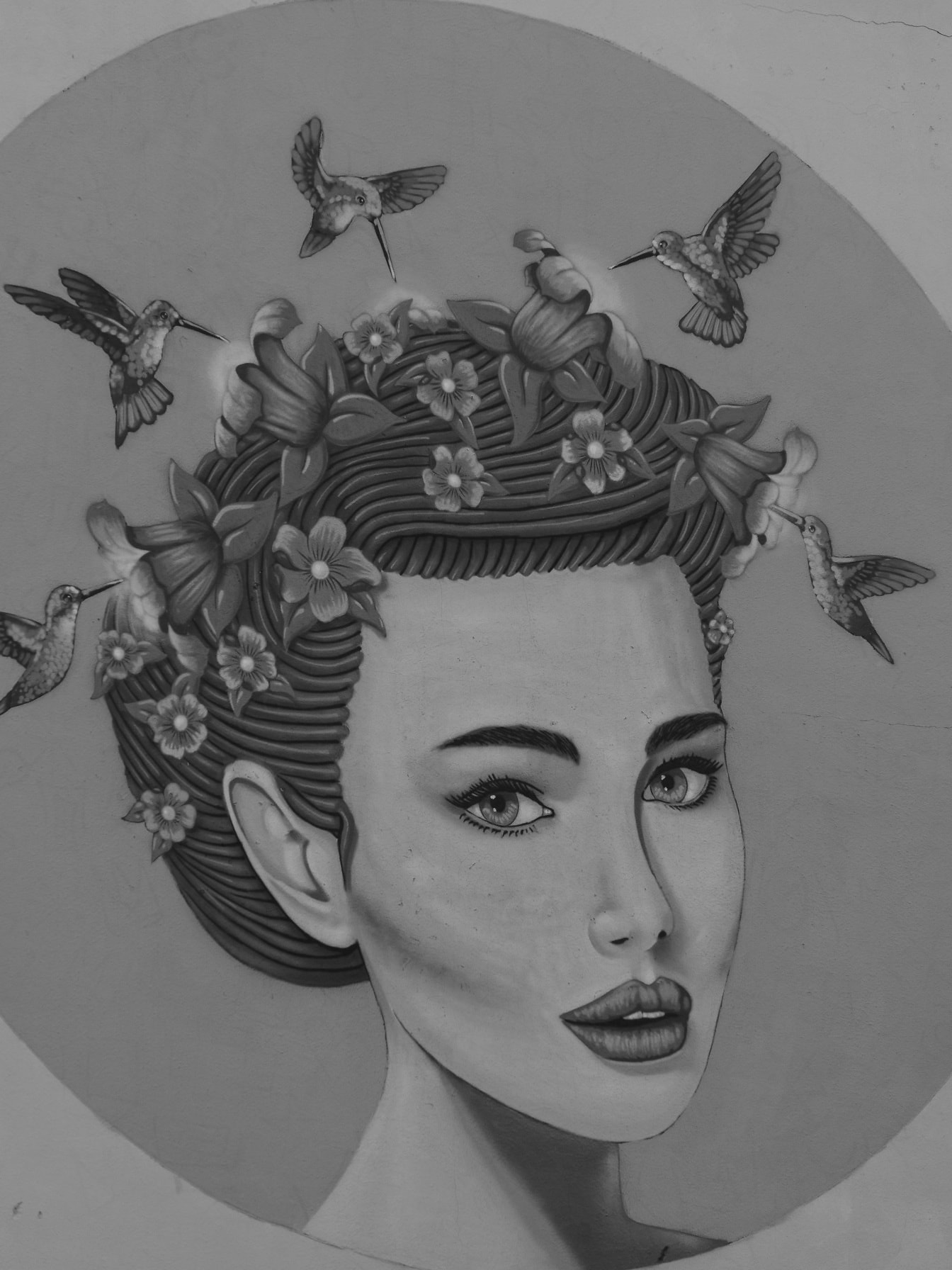 Greyscale graffiti of beautiful women with flowers and hummingbirds in hair