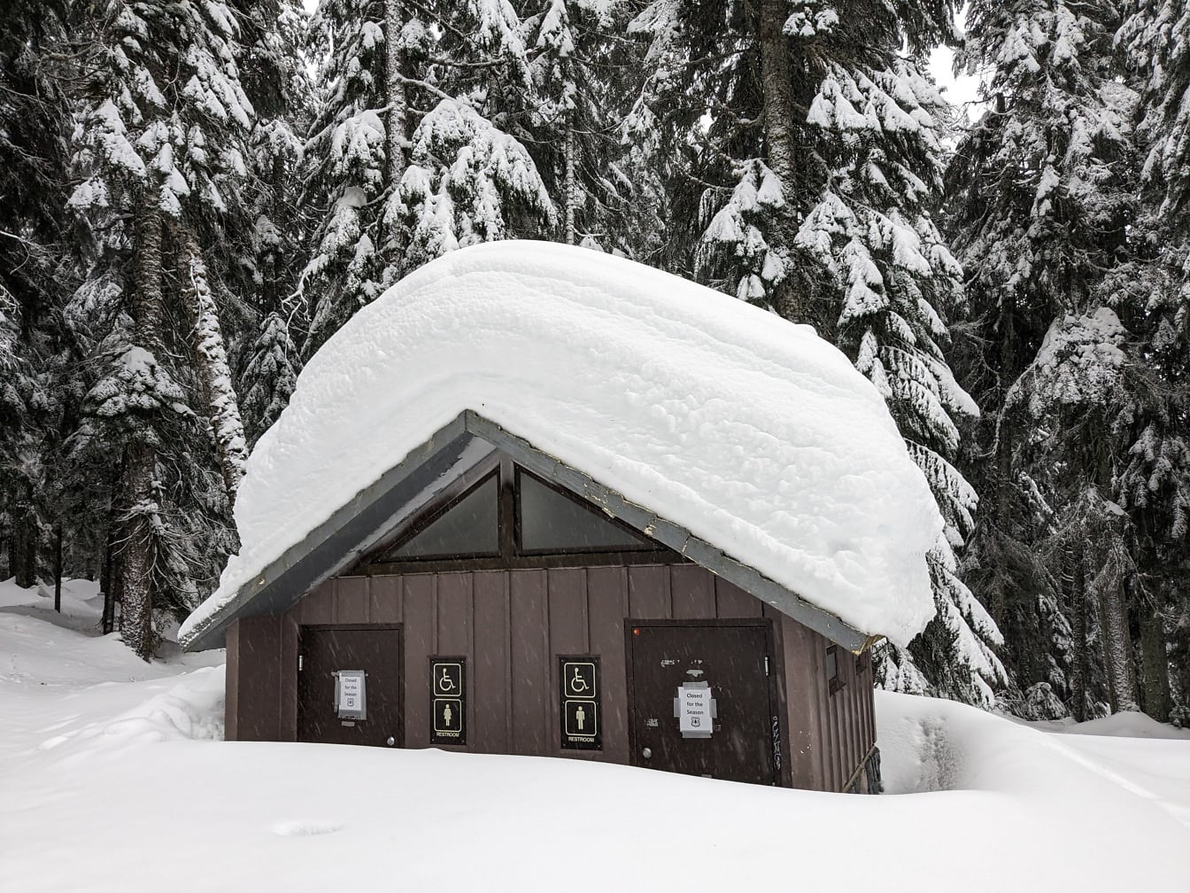 Luminen mökki-wc syvässä lumessa