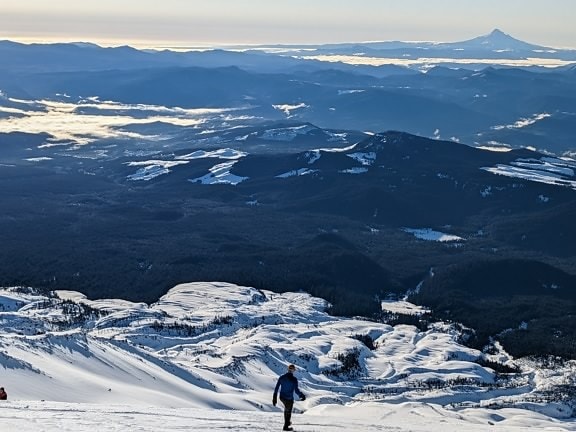 Person, die das Panorama der gefrorenen Berge und des Tals genießt