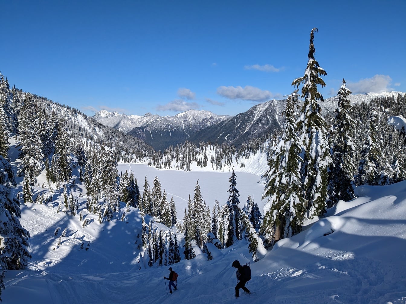 Skiers on snowy mountain slope in hiking winter adventure