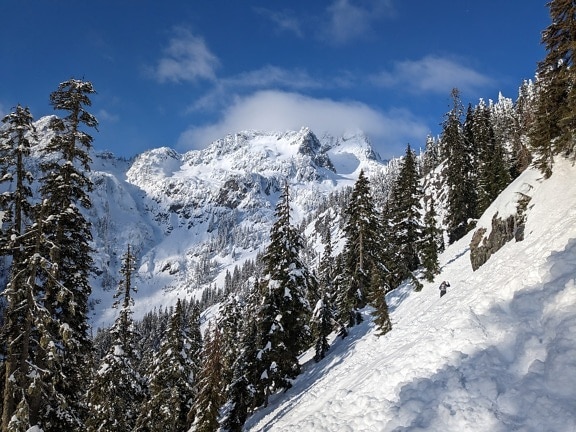 Deep snow on slope in mountains with mountain peaks in background