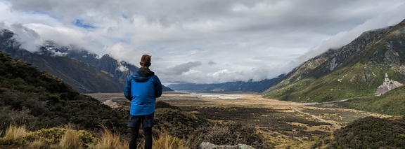 Homem em pé e desfrutando do panorama do vale