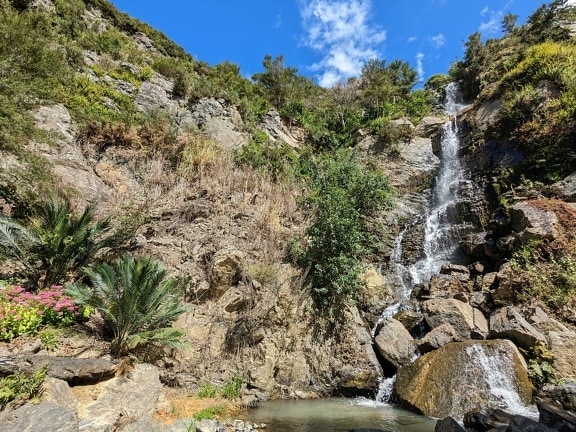 Krásný kaskádový vodopád padající do jezírka