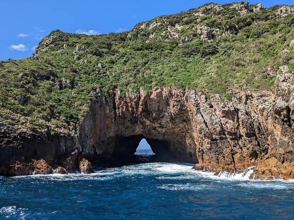Natural arch underwater passage through Aorangaia Island in New Zealand