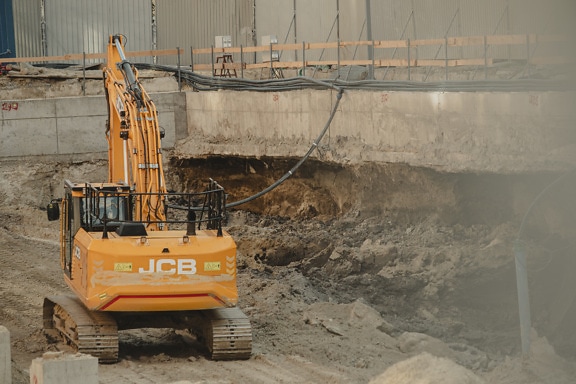 Bulldozer arbetar på smutsig grävningsbyggarbetsplats