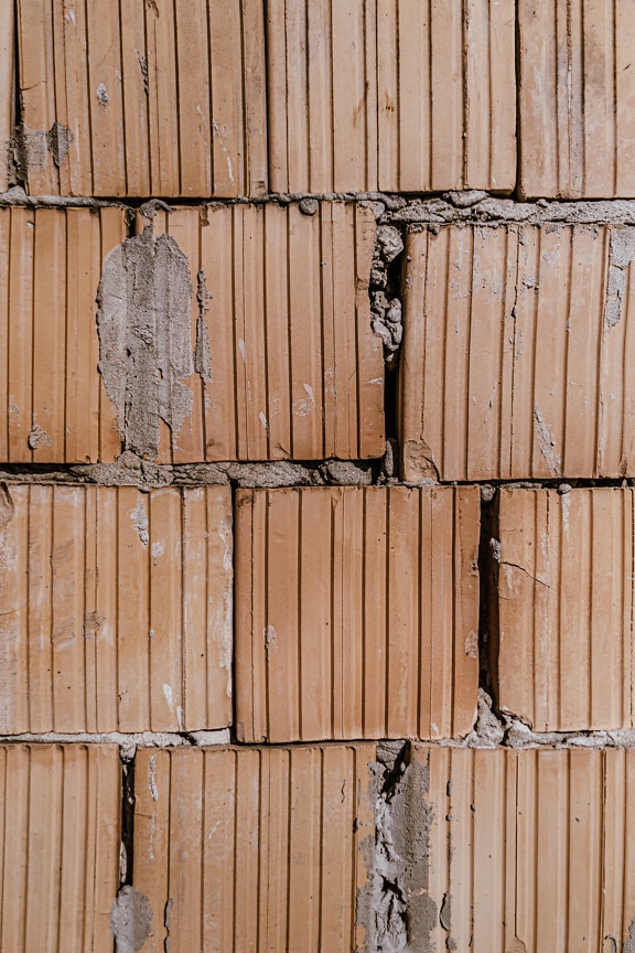 Textura de uma parede de alvenaria de blocos marrons com uma superfície áspera