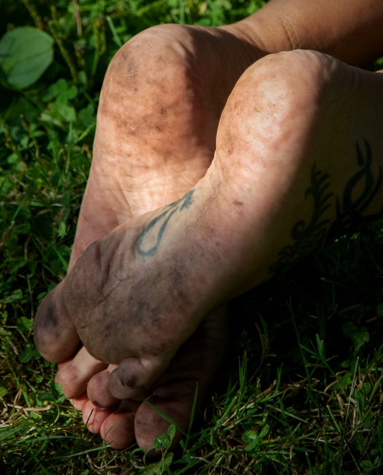 Dirty bare feet in grass close-up