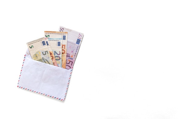 Many Euro banknotes in white envelope