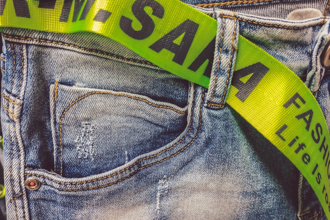 Greenish yellow fancy belt on old-fashioned blue jeans pants