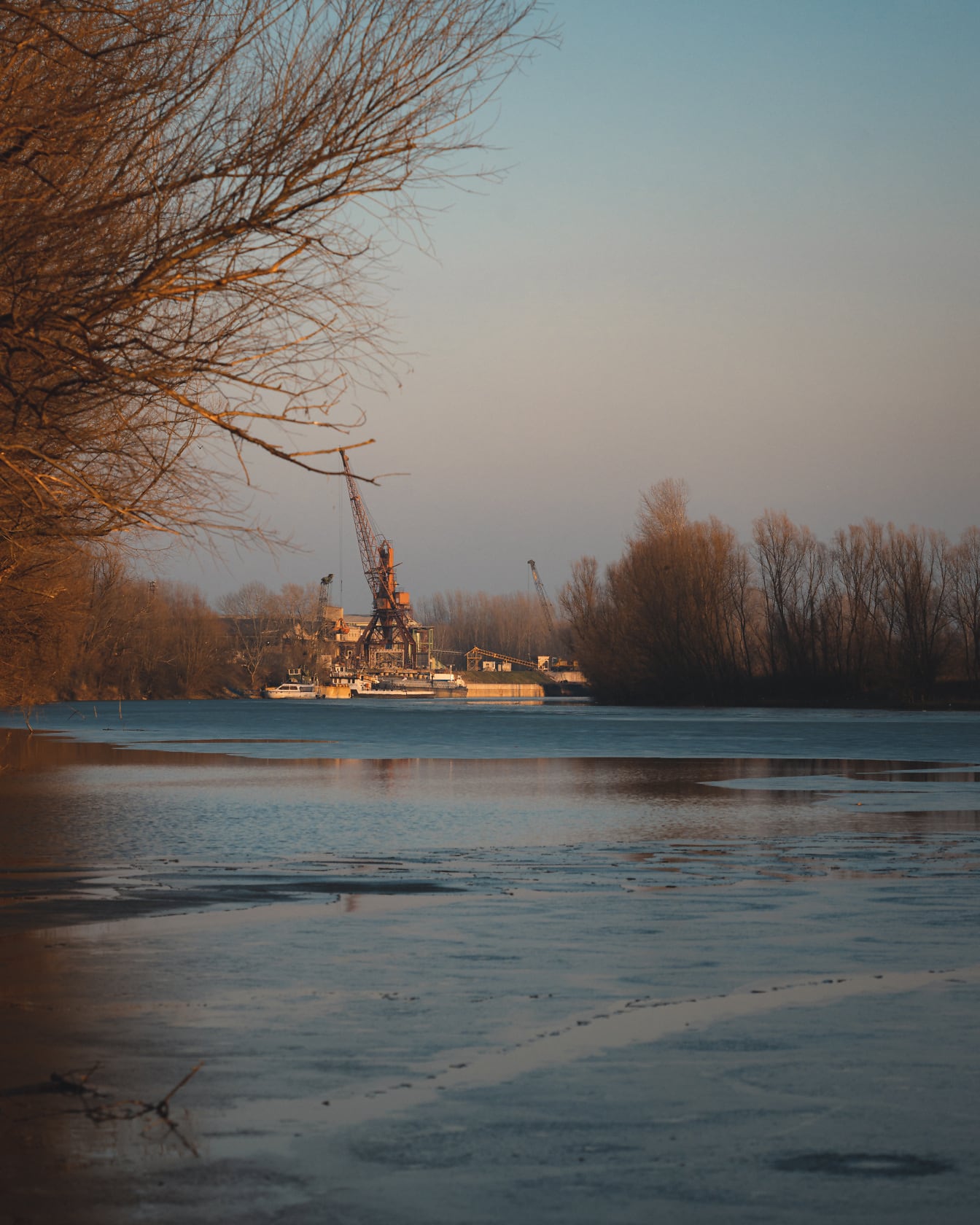 Teollisuuslaitos jäätyneellä joen rannalla