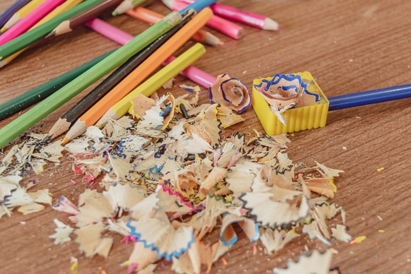 Pencil sharpener with colorful pencil shavings close-up