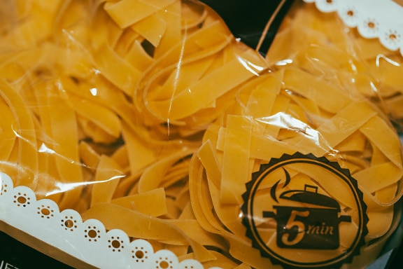 Soup noodles in transparent plastic bag close-up