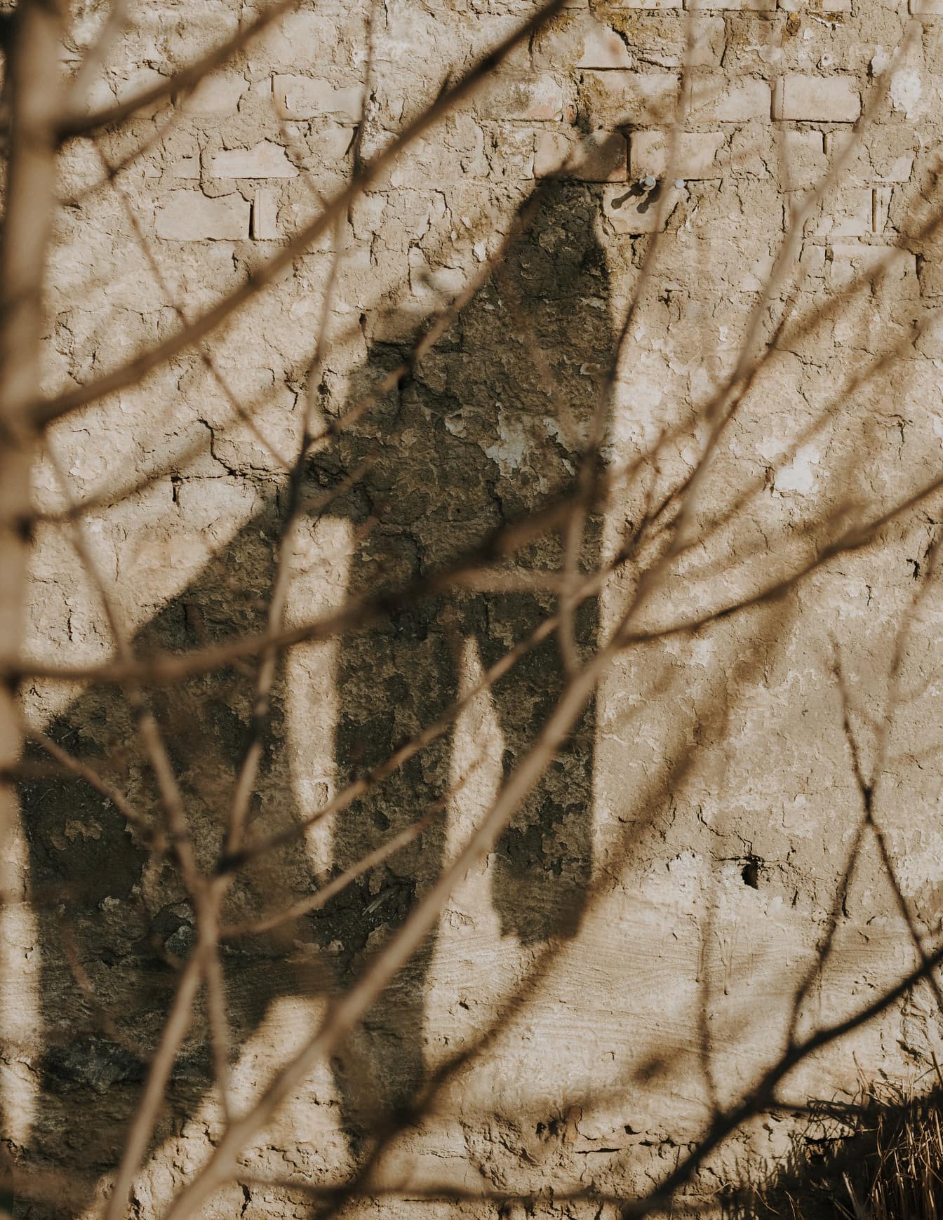 Černý stín na staré zdi z nepálených cihel