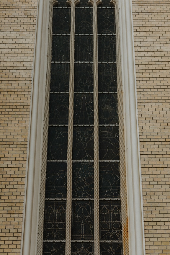 Tall gothic window on brick wall