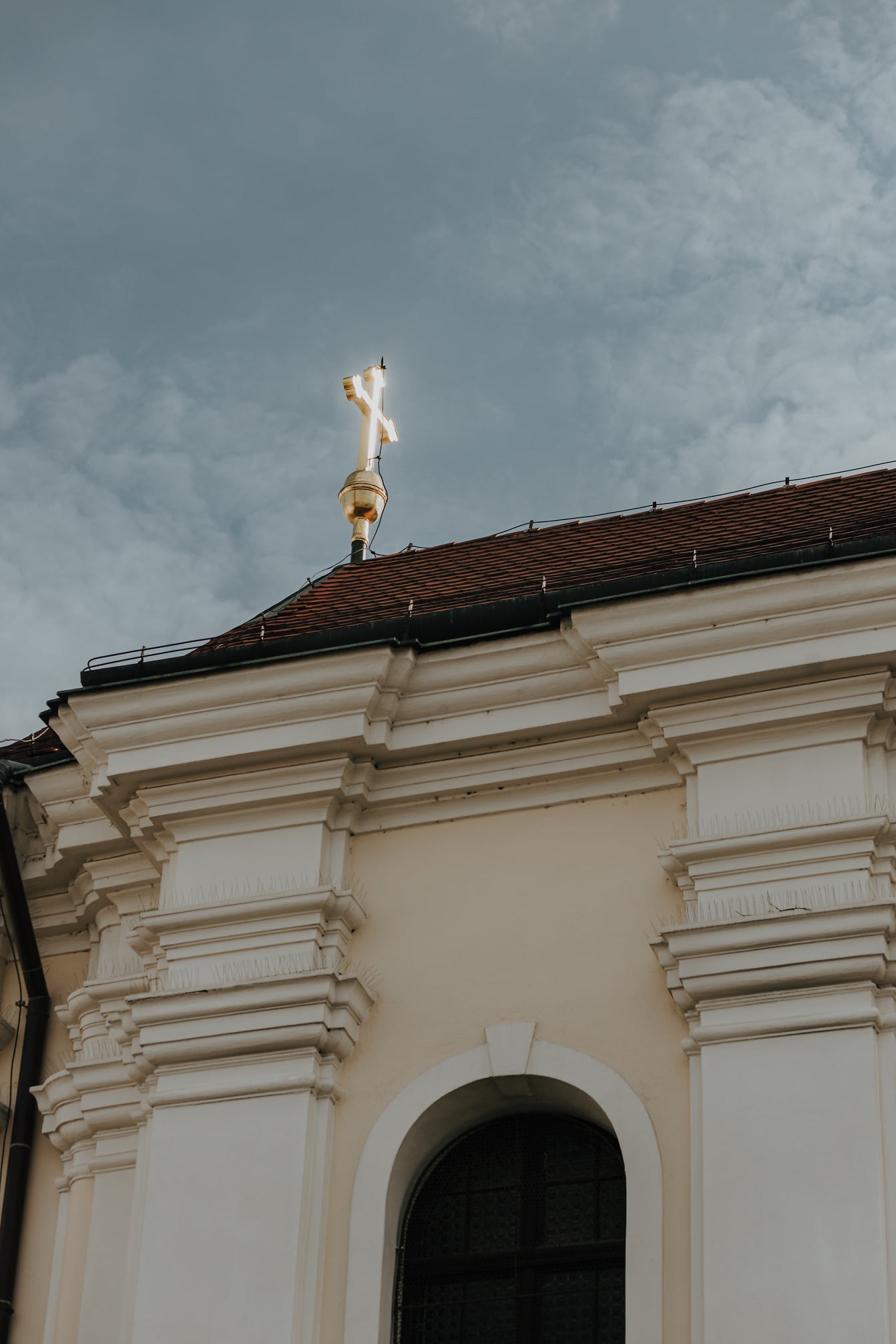 Croce dorata di bagliore sul tetto della chiesa