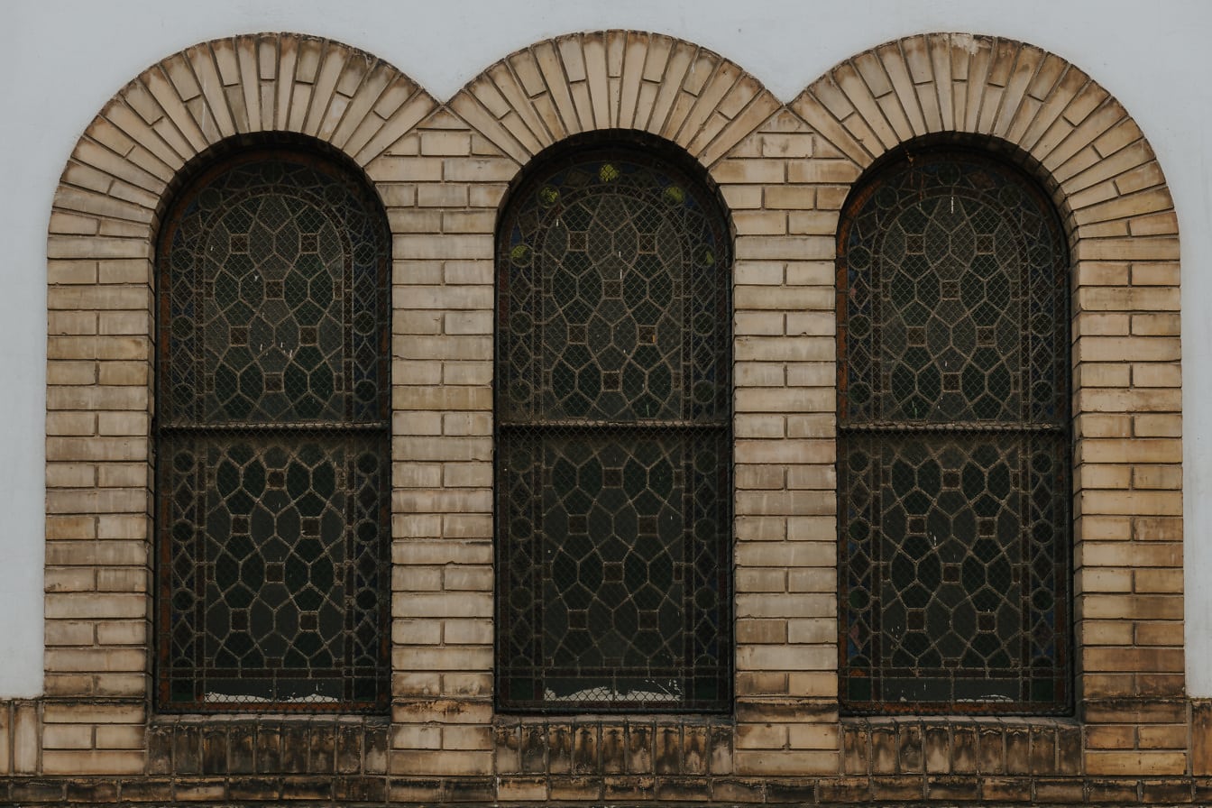 Three stained glass windows on synagogue with brick arches