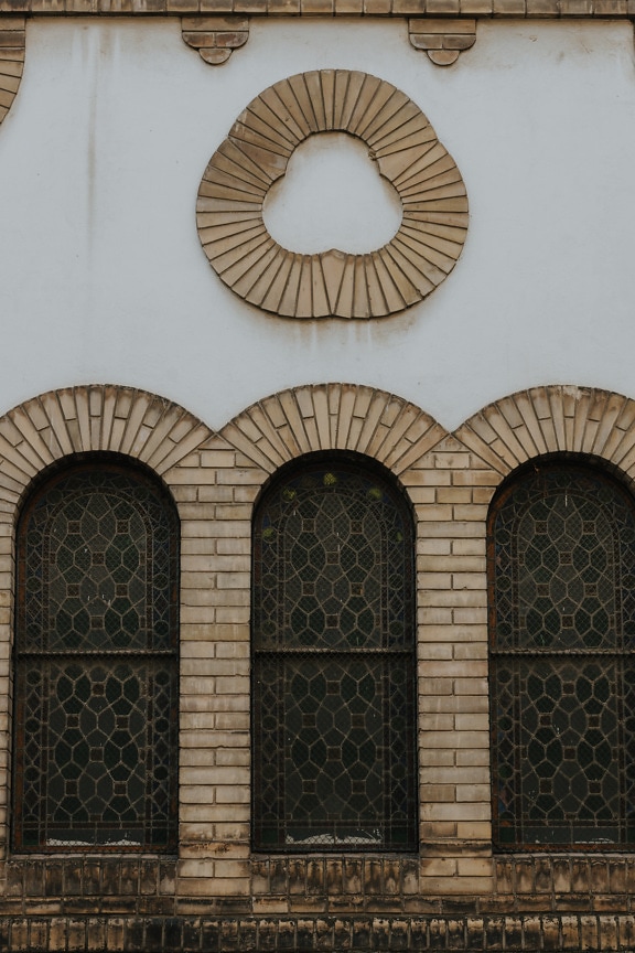 Three stained glass windows with brick arches