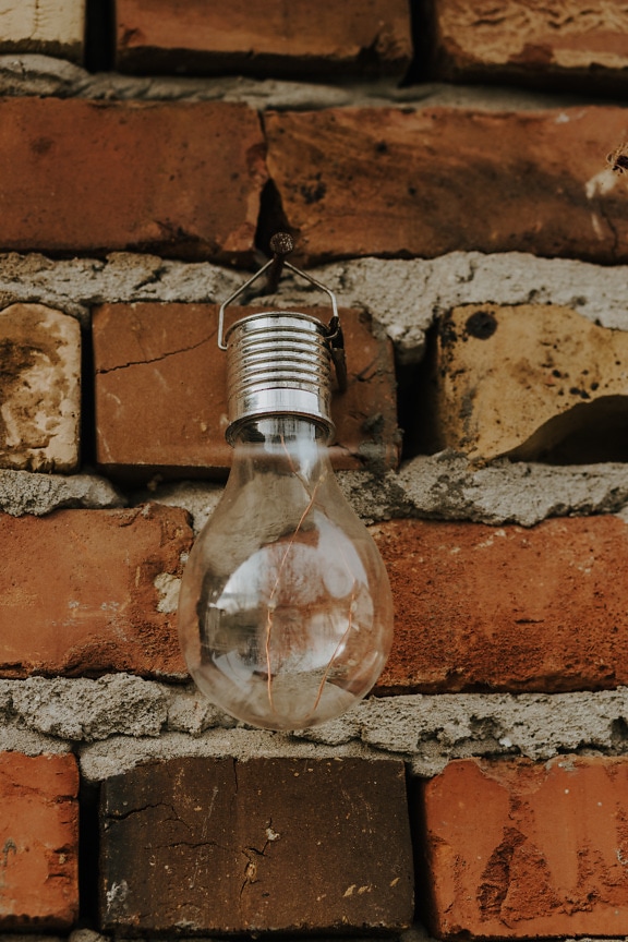 Rustic old fashioned light bulb on brick wall