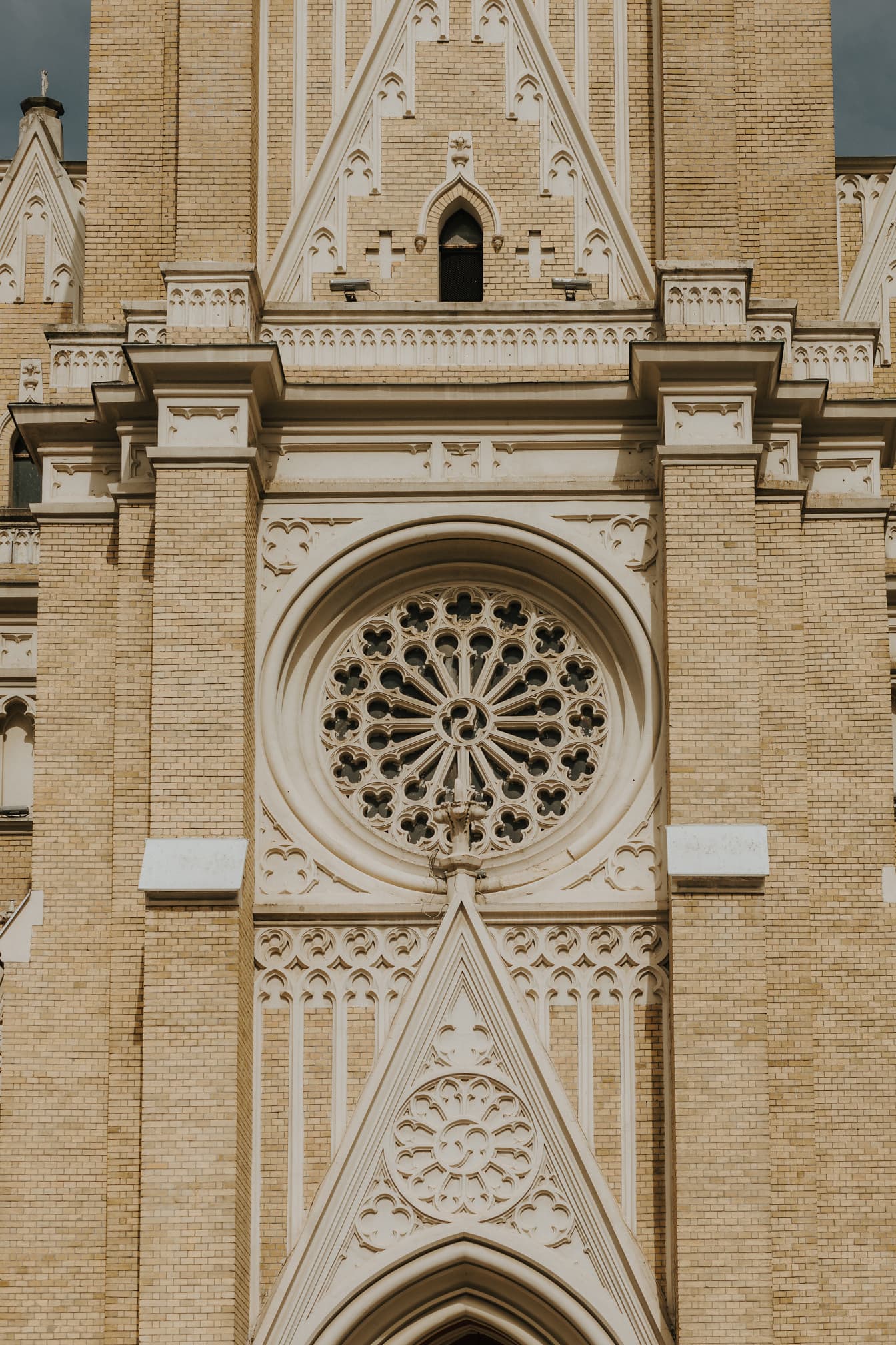 Yellowish brick facade of catholic gothic church
