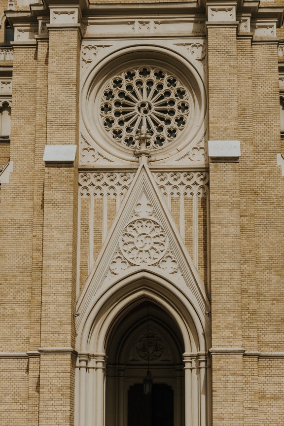 Majestic gothic facade on catholic church with yellowish brown bricks