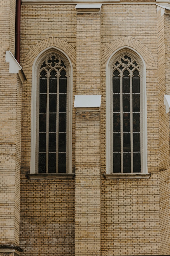 Γοτθικά ψηλά παράθυρα παλαιού στυλ σε πρόσοψη τοίχου από τούβλα