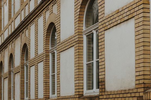 Old style white wooden windows on brick wall facade