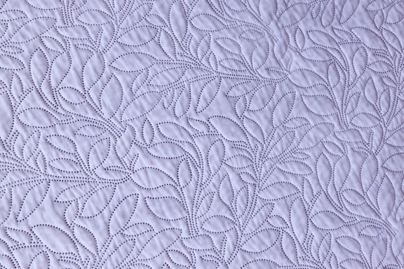 Bright purplish cotton textile with ornamental sewing texture