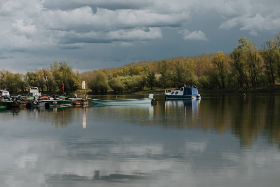 Several fishing boats on calm lake in summer season