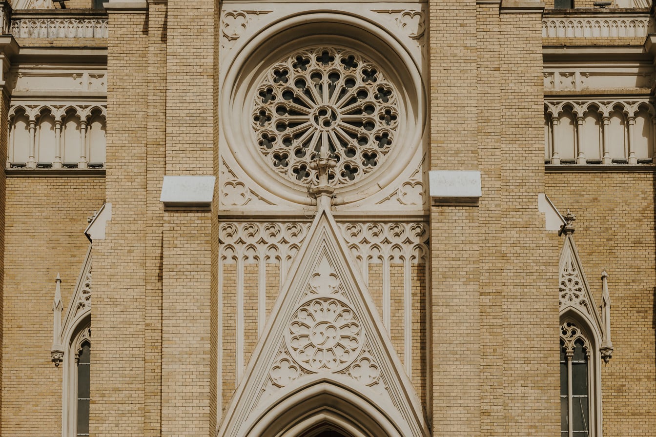 Janela circular com ornamento gótico na parede de tijolos