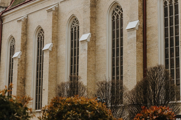 Hoge verticale gotische vensters op bakstenen muur